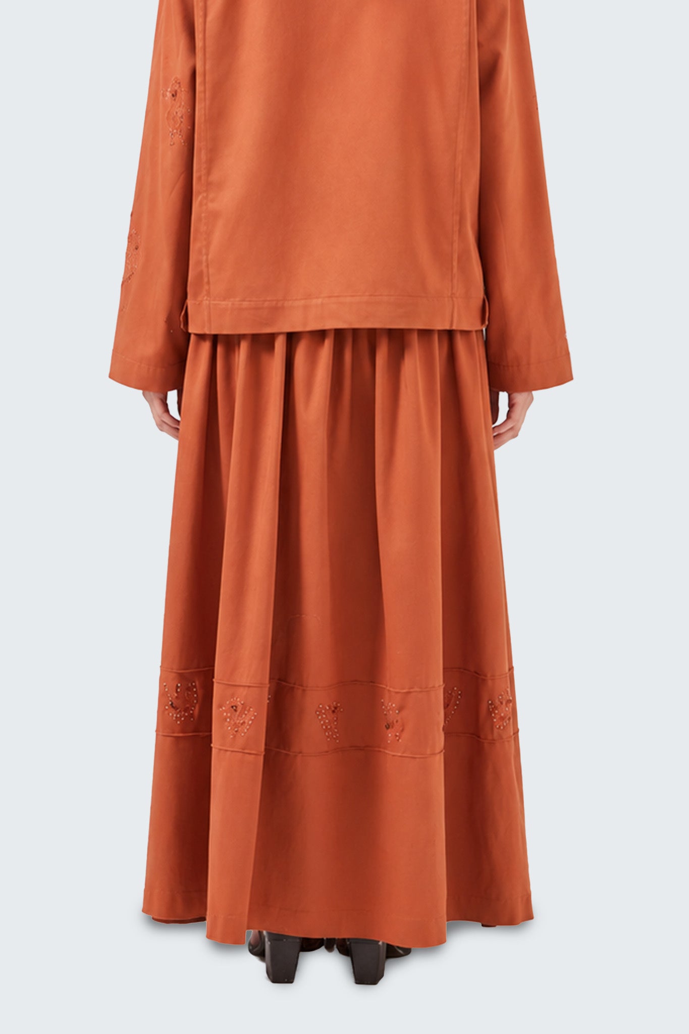 Detailed back view showcasing the skirt's gathered construction, flowing silhouette, and artisanal embellishments.