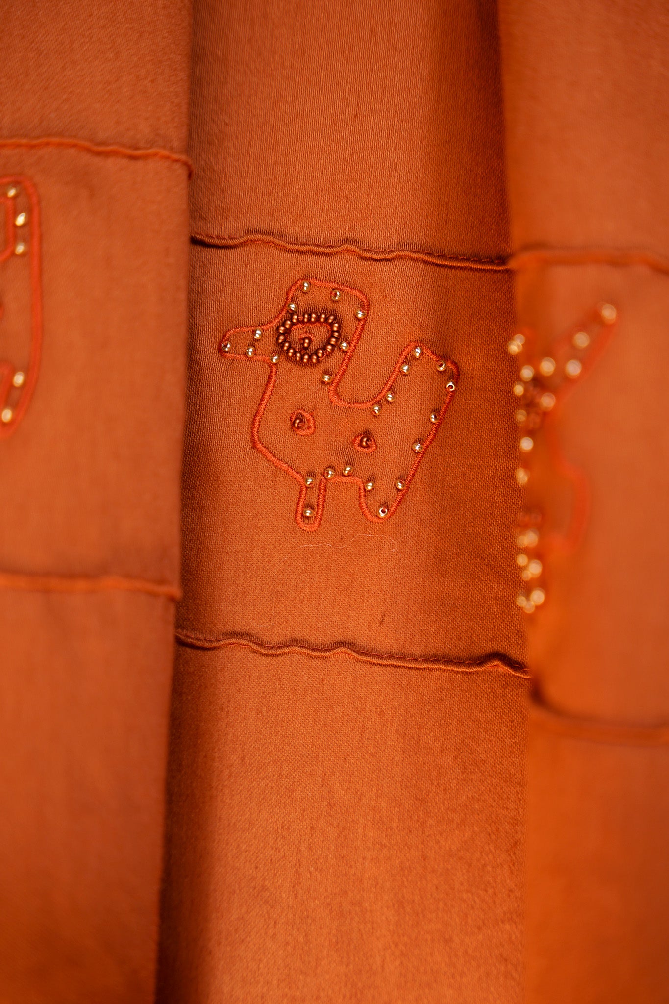Close-up of the archive-inspired embroidered and beaded motif featured on the lower panel of the Tolita skirt.