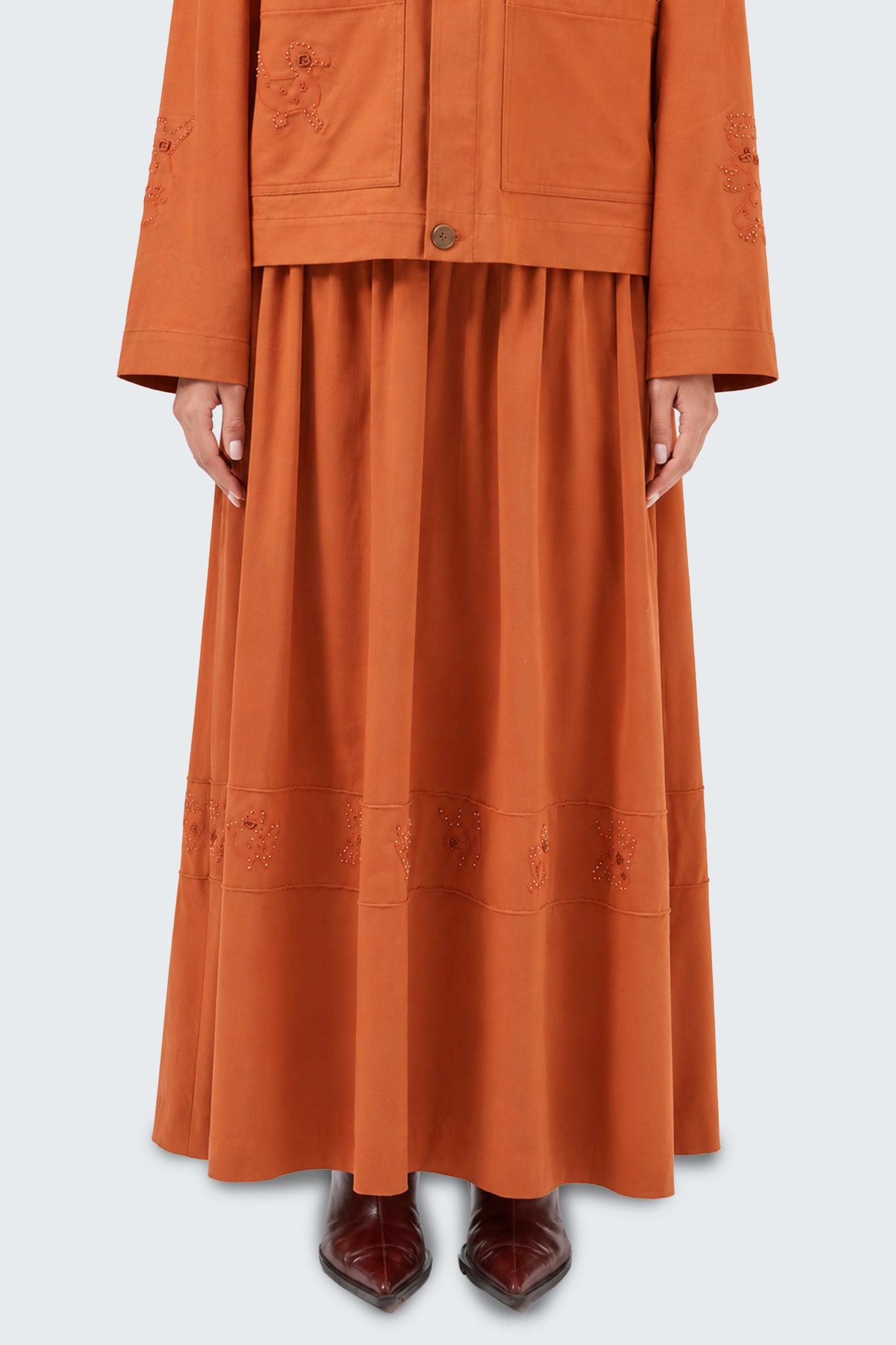 Detailed front view emphasizing the gathered construction, embroidered accents, and refined craftsmanship.