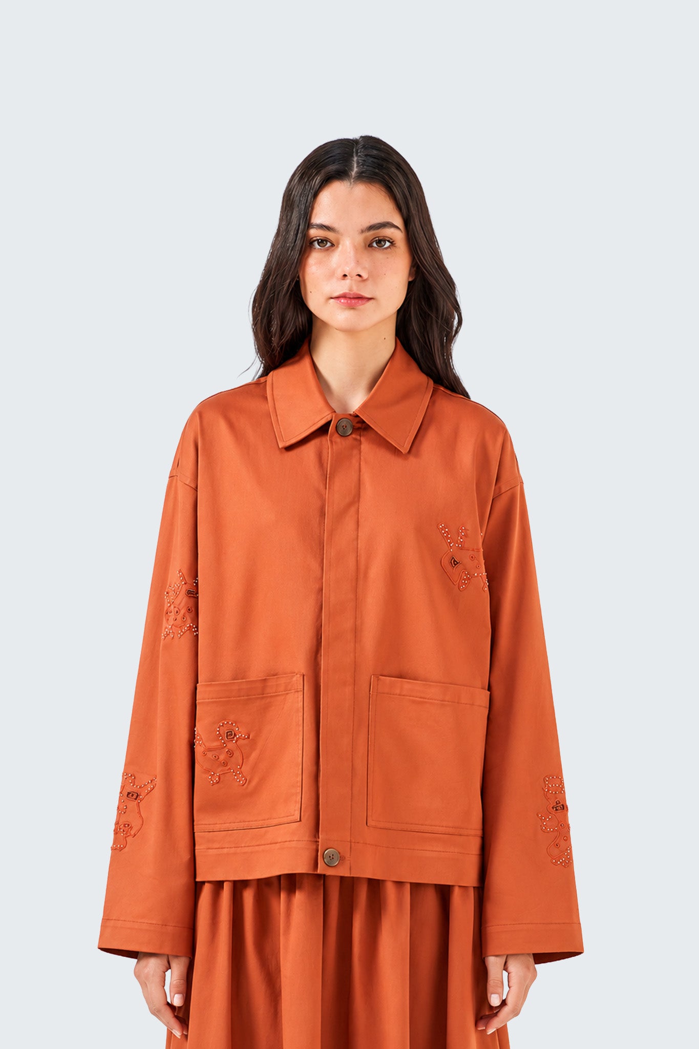 Woman wearing an orange jacket on a white background