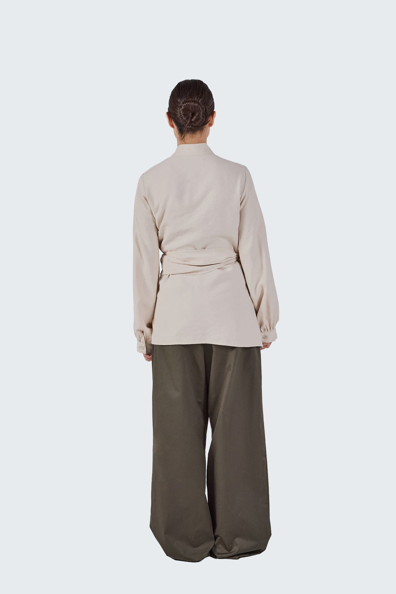 Back view of the Zigze Knotted Blouse showing the clean tailored silhouette, wrapped waist detail, and softly gathered sleeves.