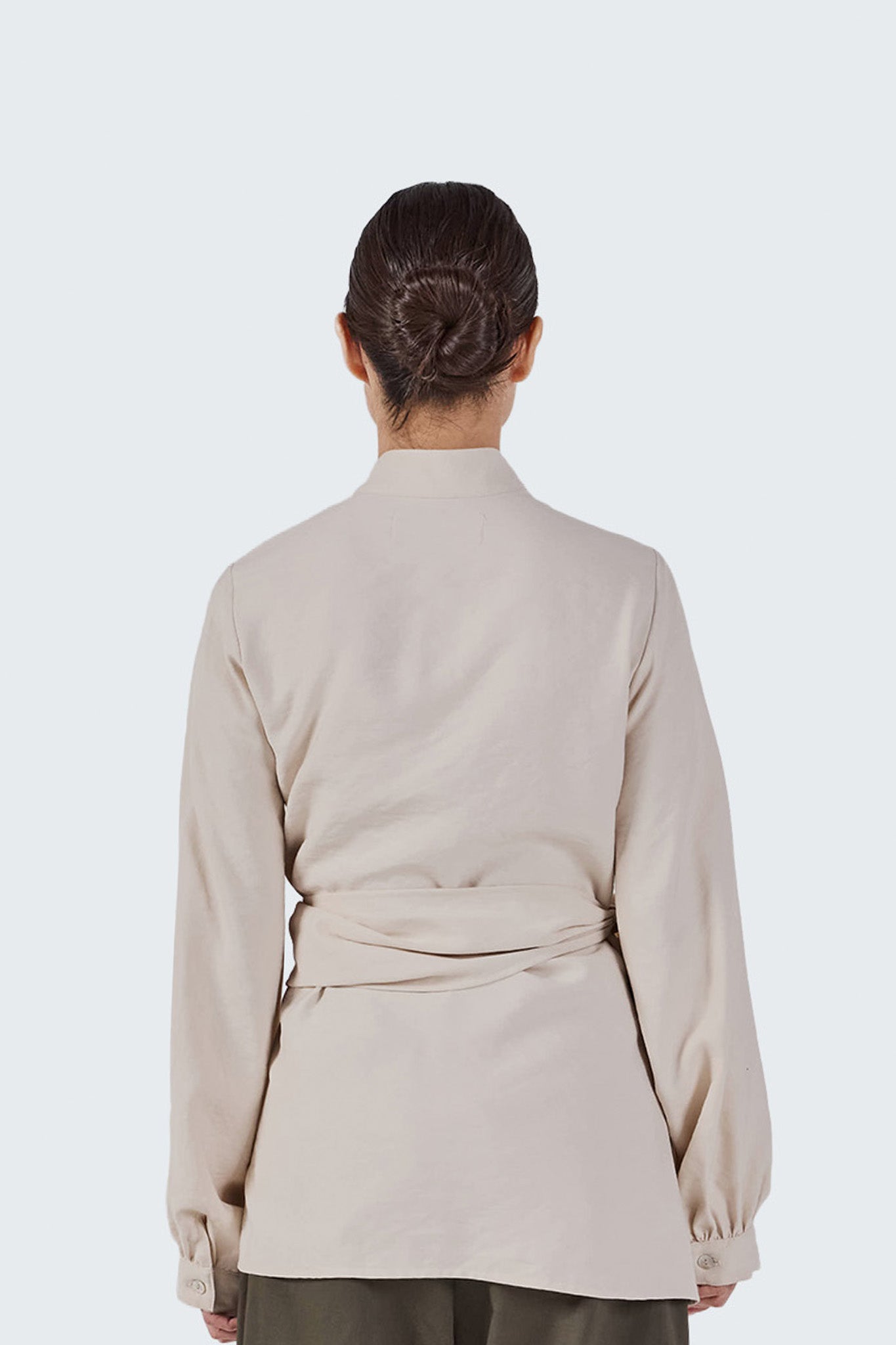 Back detail of the Zigze Knotted Blouse showcasing the crossover waist wrap and refined construction in Off-White fabric.