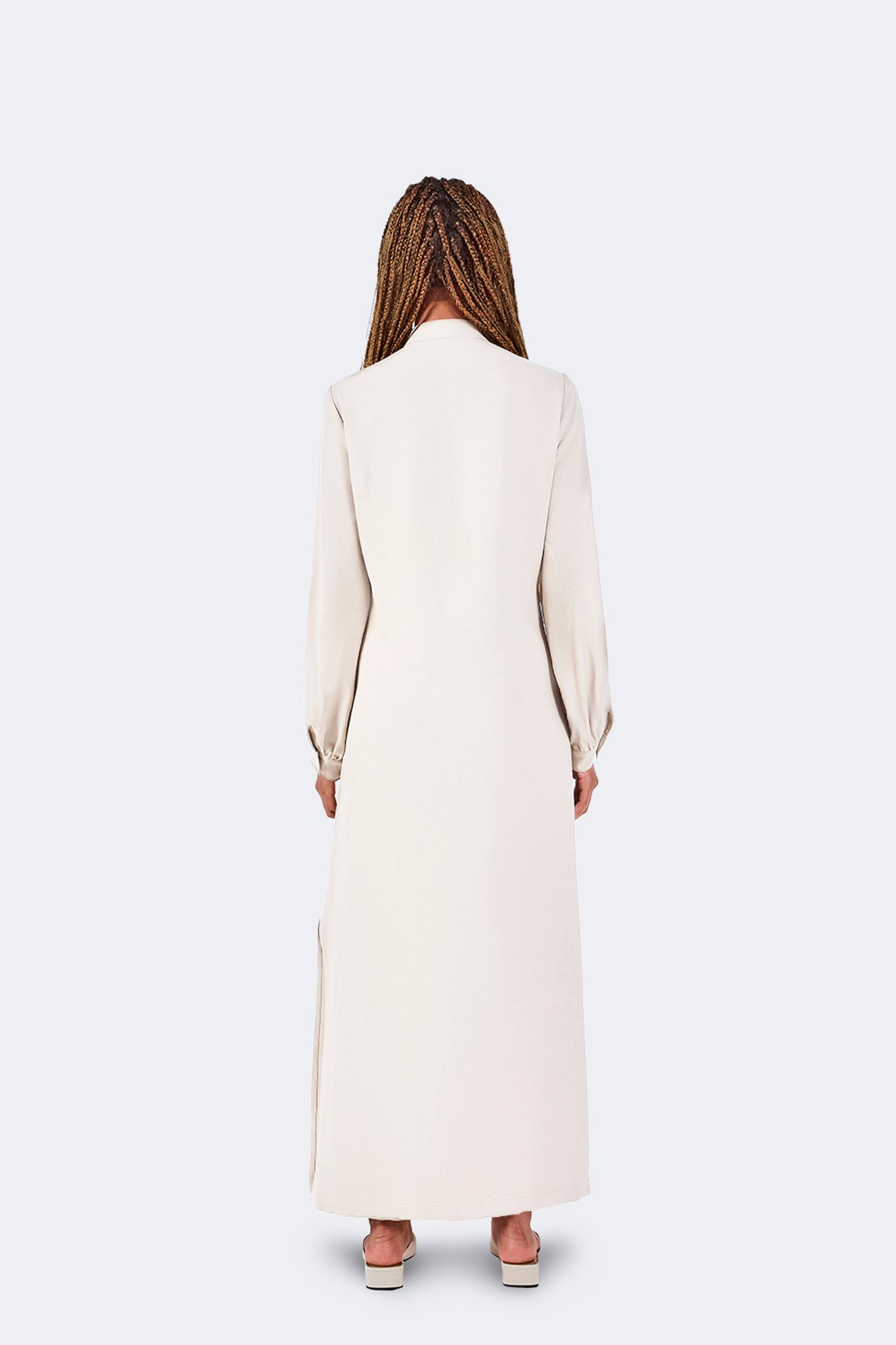 Back view of the Zigze Knotted Dress in Ivory featuring a full-length silhouette, soft fluid drape, long sleeves, and clean tailored construction.
