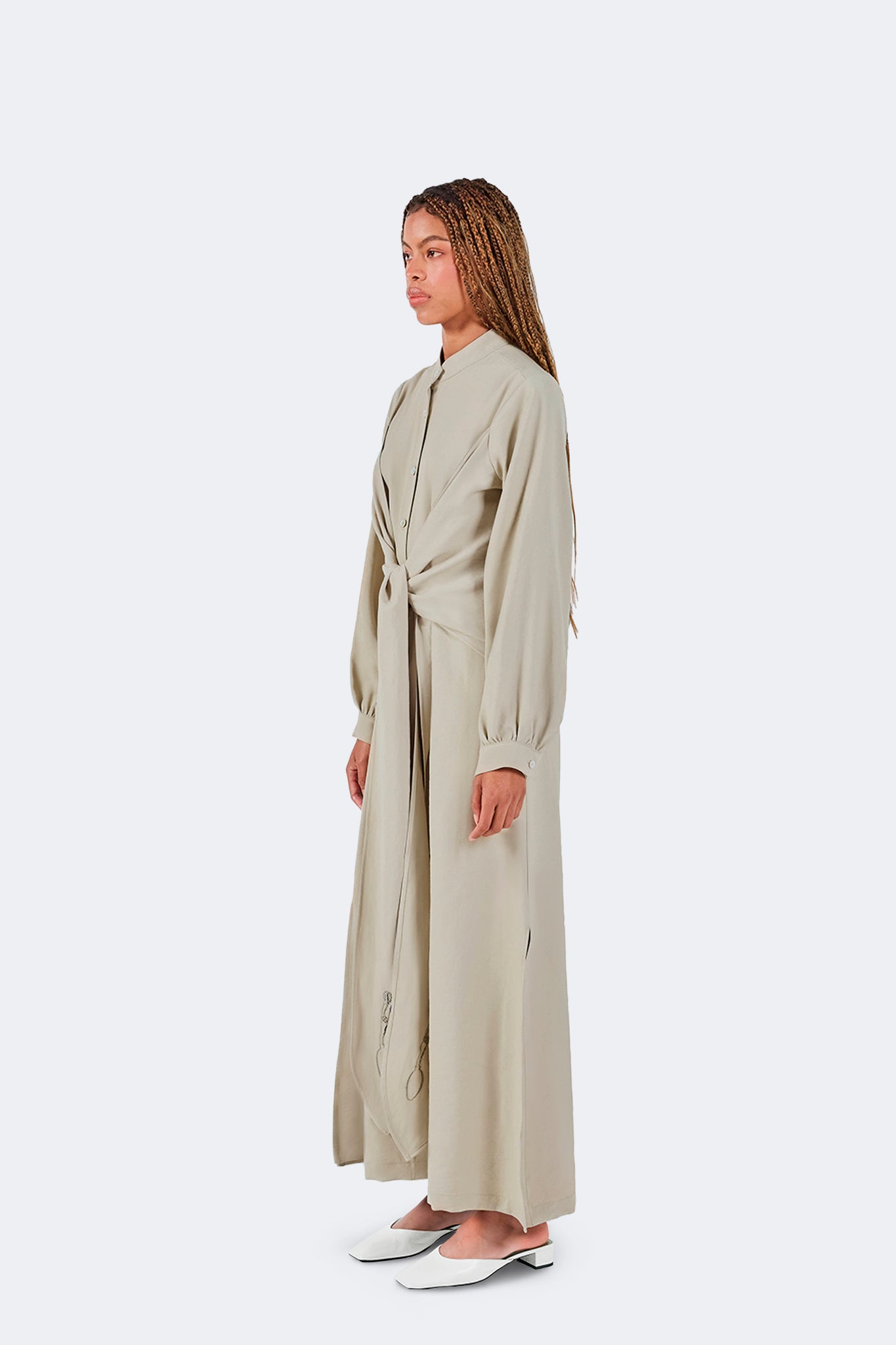 Side view of the Zigze Knotted Dress in Baby Moss highlighting its fluid drape, architectural silhouette, side slit detail, and elegant proportions.