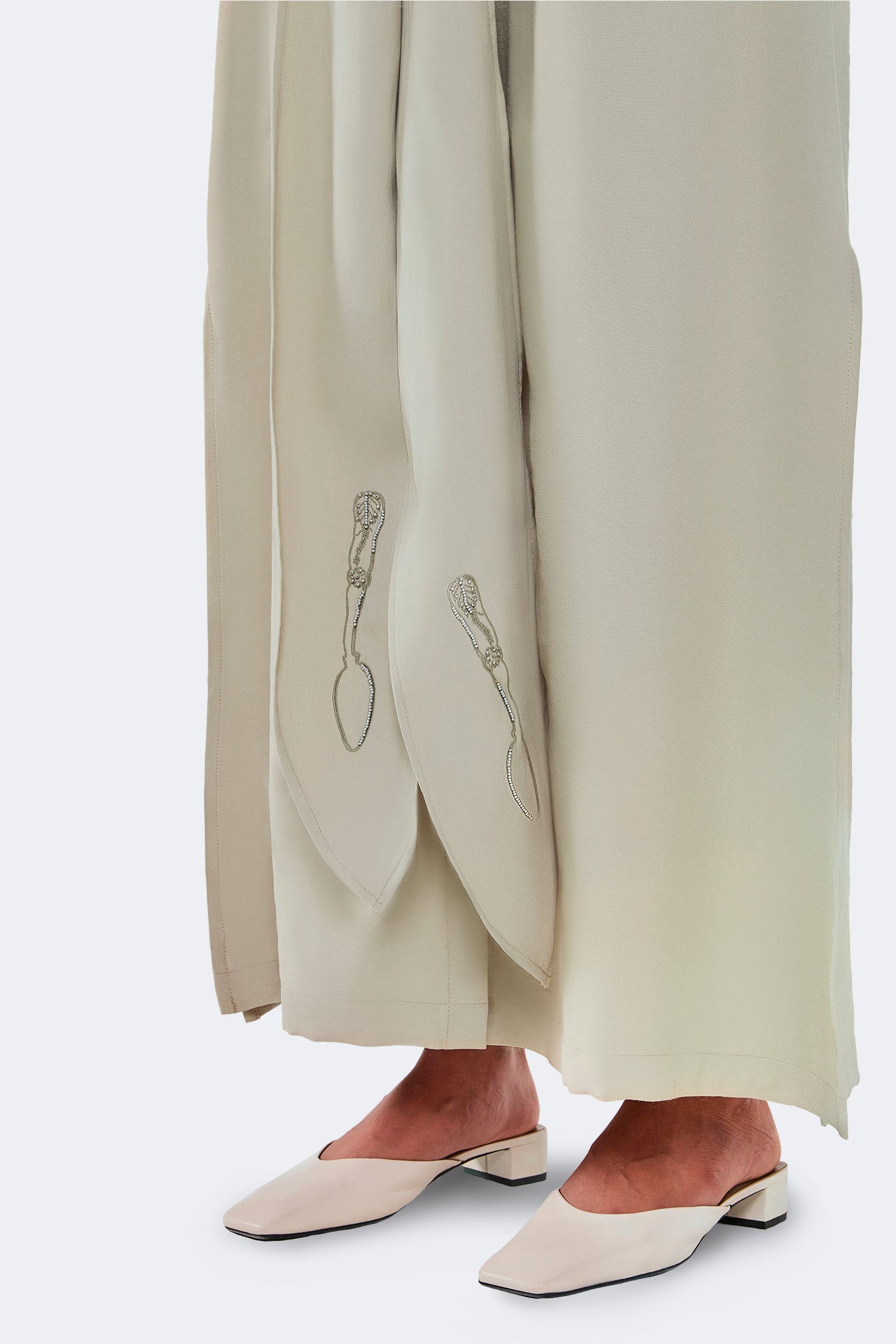 Close-up of the Zigze Knotted Dress showing archive-inspired embroidered accents on the elongated front ties and soft woven fabric.